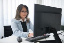 Profissional trabalha diante de um computador em um escritório moderno.