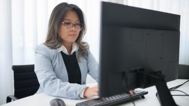 Profissional trabalha diante de um computador em um escritório moderno.